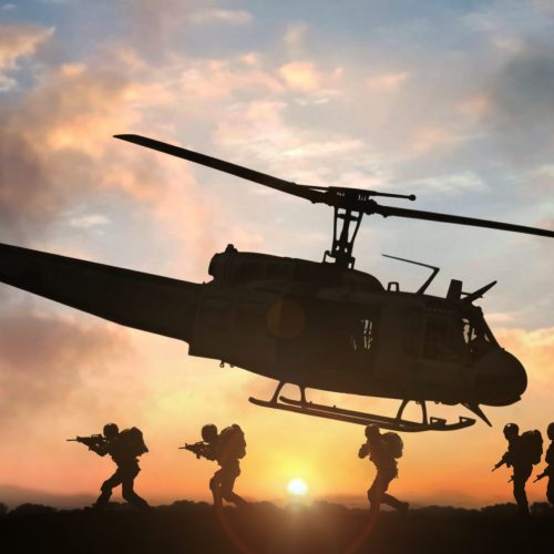 Military special force assault team helicopter drops during sunset